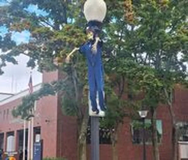 A scarecrow decoration mounted on a downtown lamp post