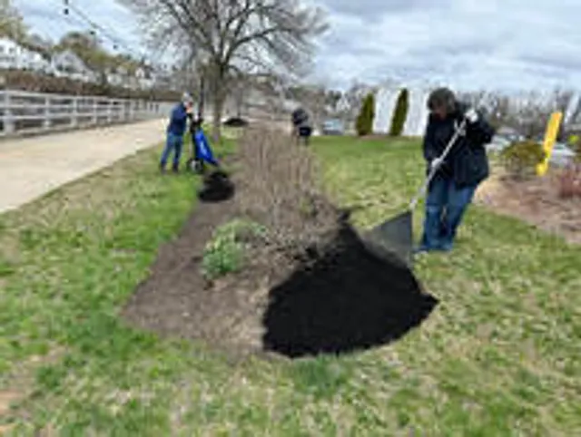 Volunteers spreading fresh mulch in the planting beds along the Cocheco Riverwalk