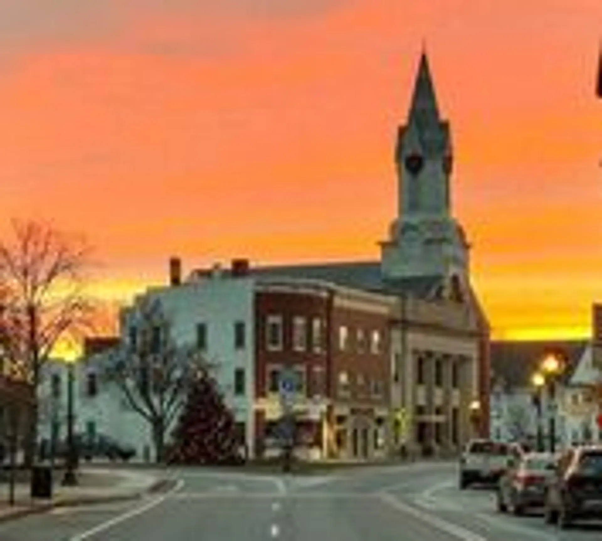 A historic downtown Rochester building and its clock tower at sunset
