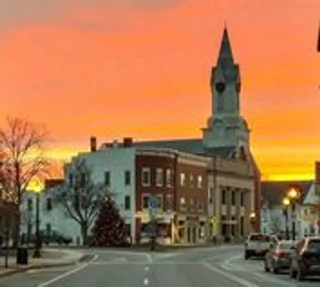 A historic downtown Rochester building and its clock tower at sunset
