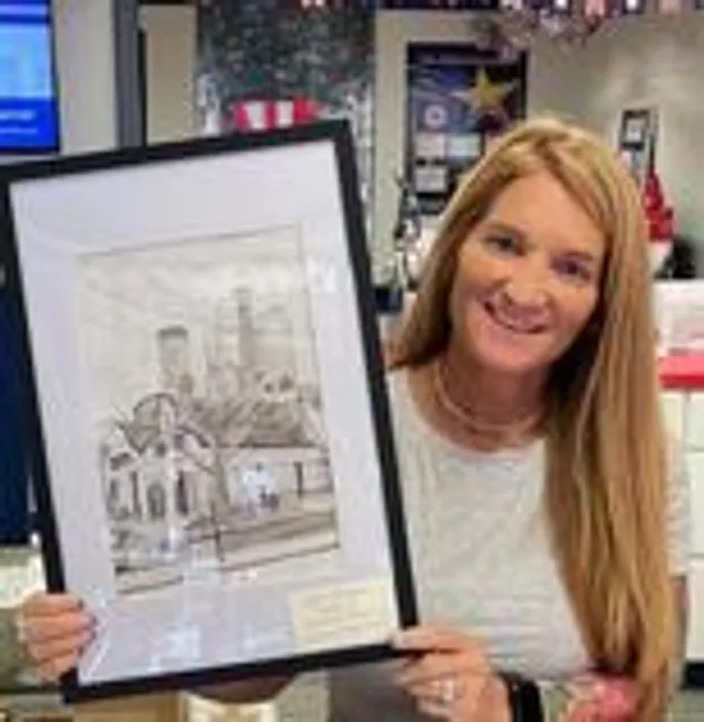 A framed student drawing of downtown Rochester presented for the Student Art Walk