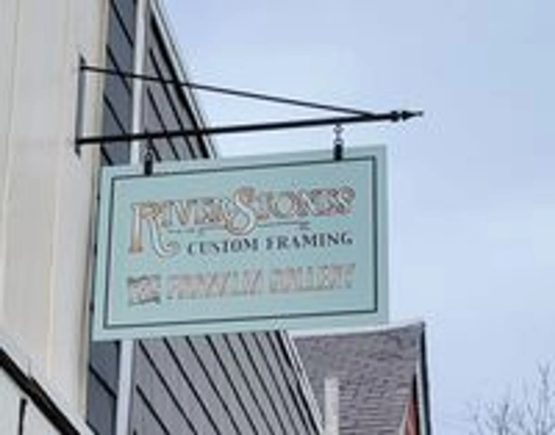 A classic hanging storefront sign at a downtown Rochester business