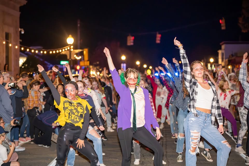 Costumed dancers performing in the Zombie Walk through downtown Rochester at night